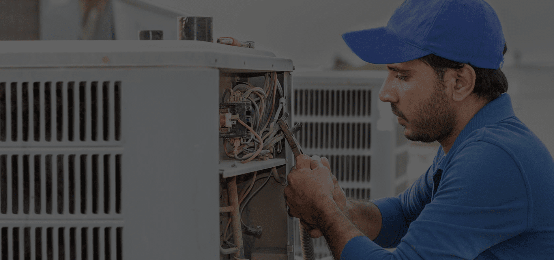 Professional technician repairing outdoor air conditioning unit.
